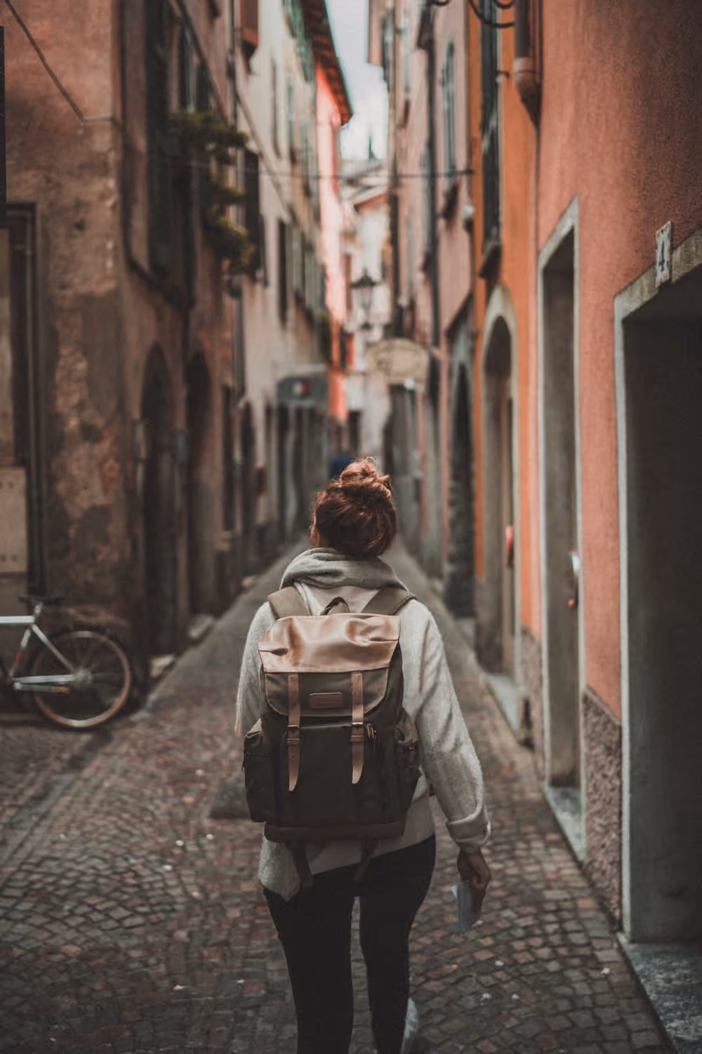 A traveller with a backpack walking down a narrow street