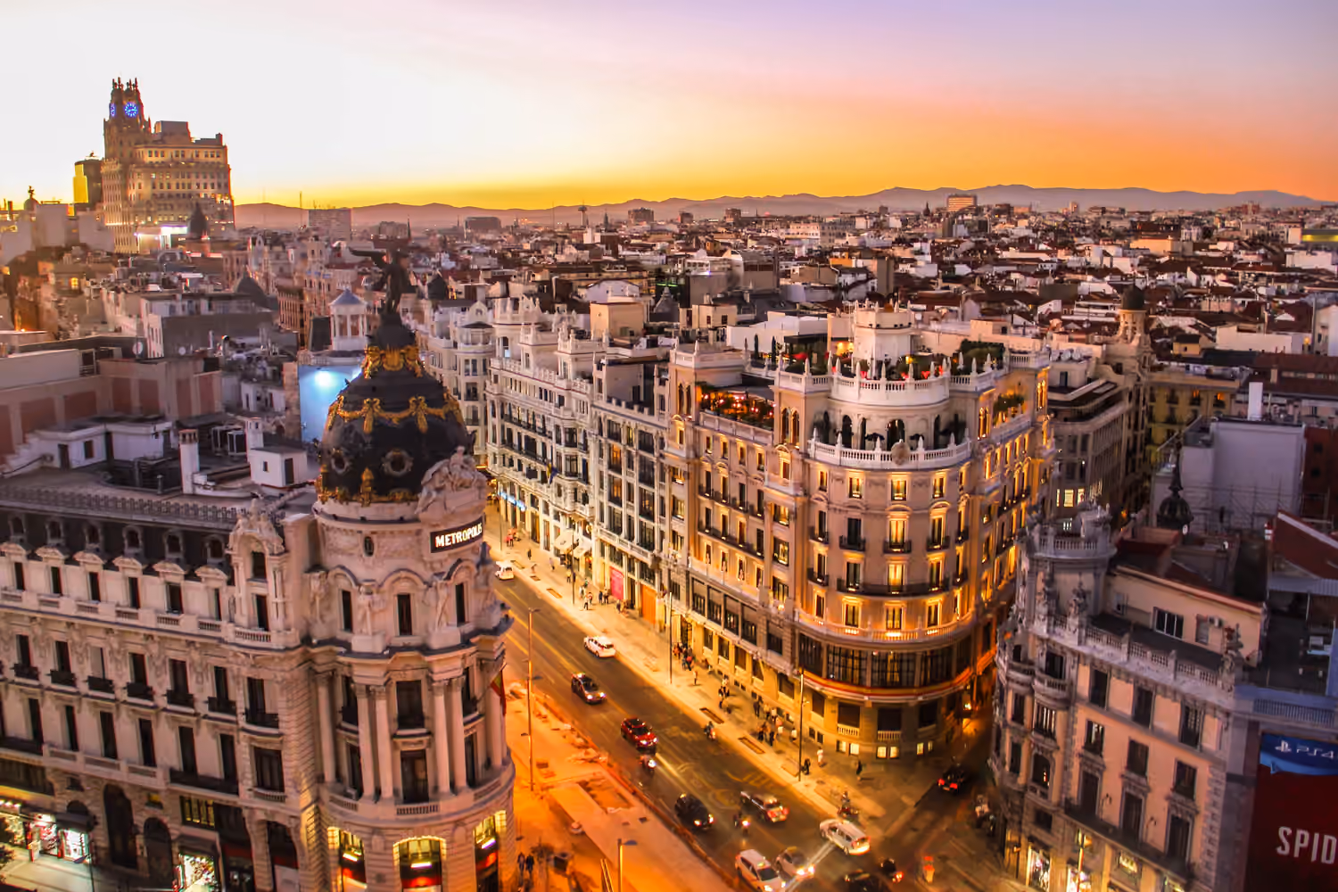 Barcelona skyline at sunset with a busy avenue below